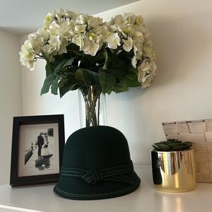 Beautiful dark green hat with stitching around it.